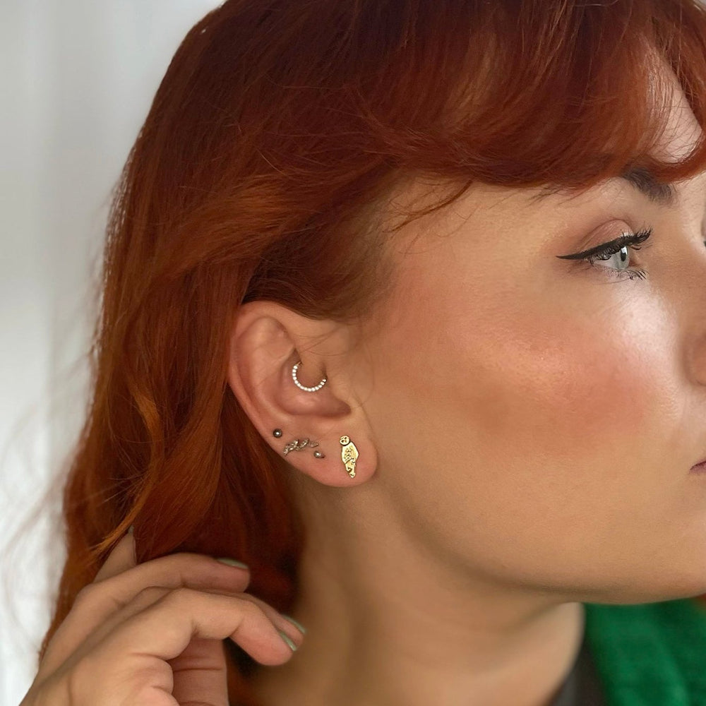 Blackbird Jewellery close-up of model wearing Barn Owl Earrings in 18ct Gold Vermeil, featuring intricate feather-like detailing