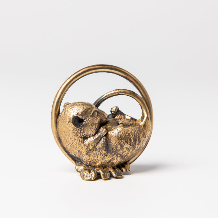 Bronze sculpture of a sleeping dormouse nestled in an intricately designed nest