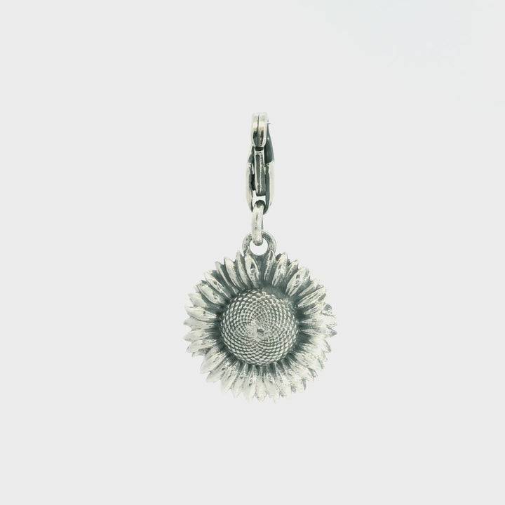 Close-up turnaround of recycled sterling silver sunflower charm showing clasp and petal detail