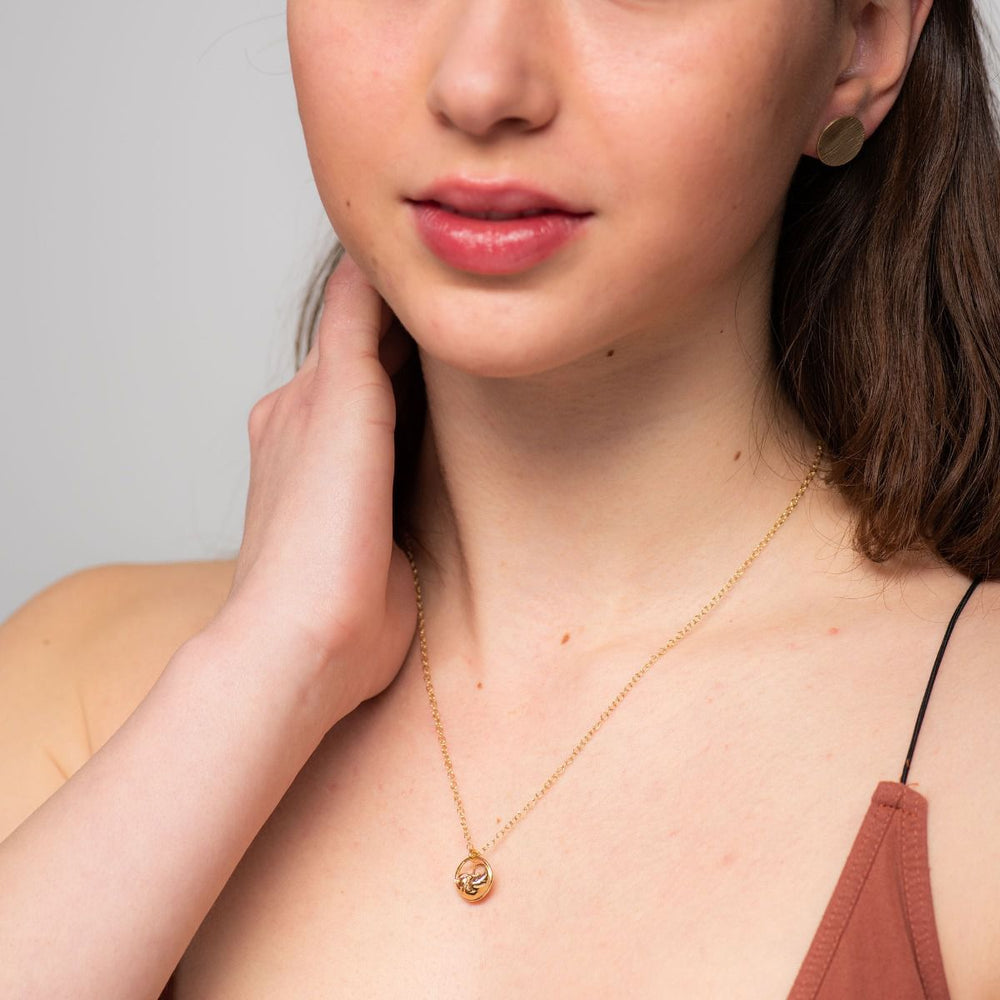 Model wearing gold vermeil sleeping dormouse necklace – nature-inspired conservation jewellery by Blackbird Jewellery