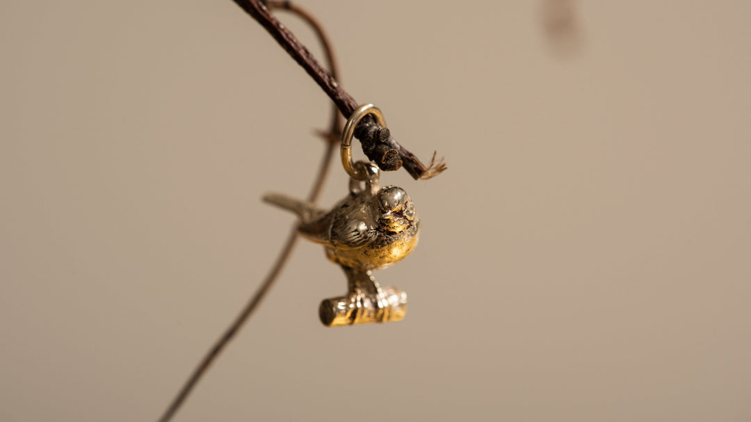 Close-up of Blackbird Jewellery gold vermeil robin charm necklace, symbolising love and connection.