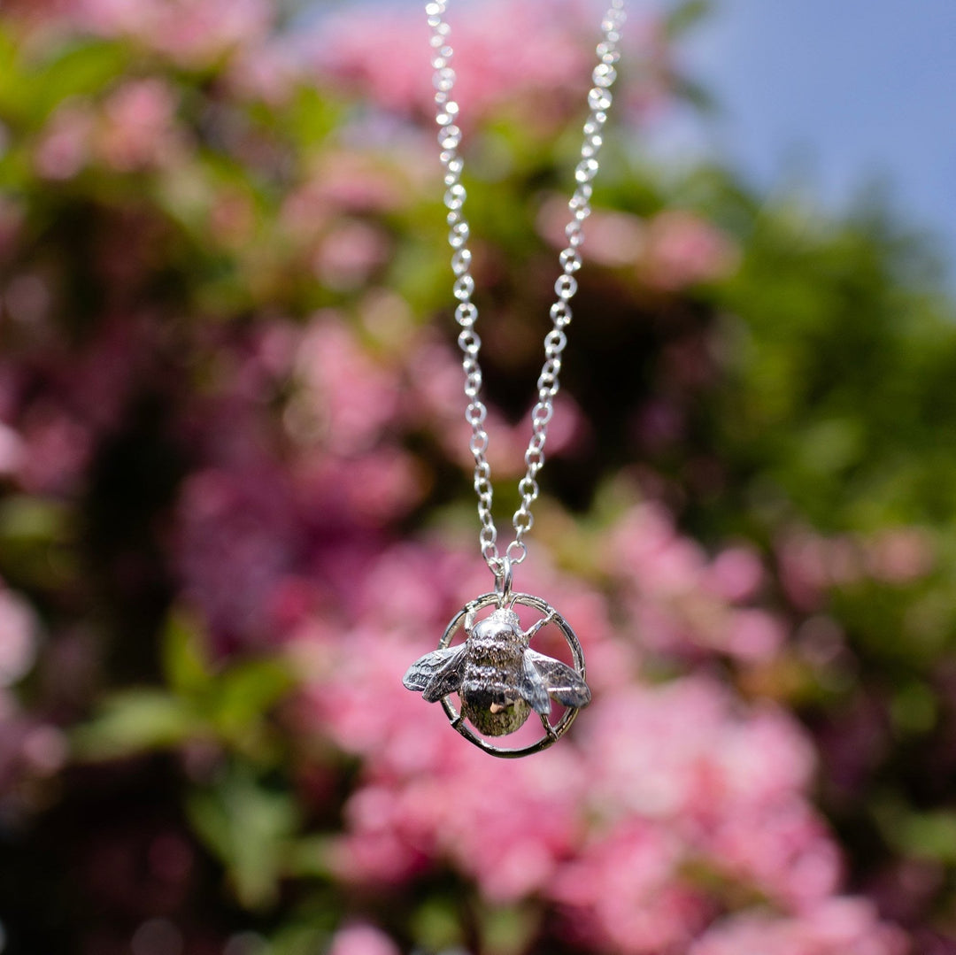 Close-up of a sterling silver Queen Bee necklace featuring intricate wings and crown detail, symbolising strength and elegance.