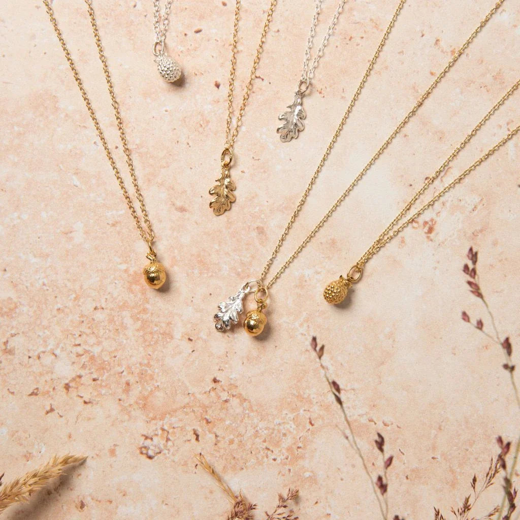 Handmade oak leaf and acorn charm necklaces in sterling silver and gold vermeil from Blackbird Jewellery’s Woodland collection.