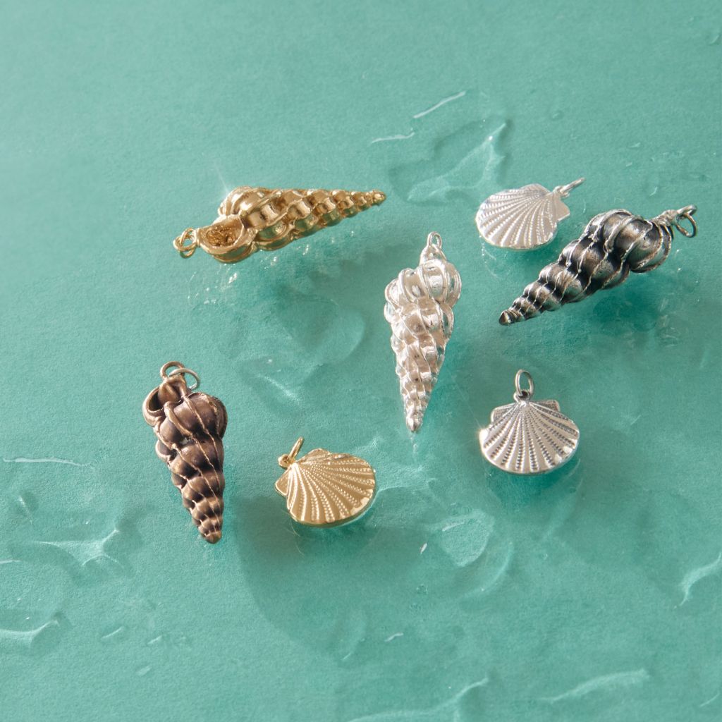 Handmade shell and pebble charm necklaces in gold vermeil and sterling silver from the Blackbird Jewellery Sea & Shore collection.