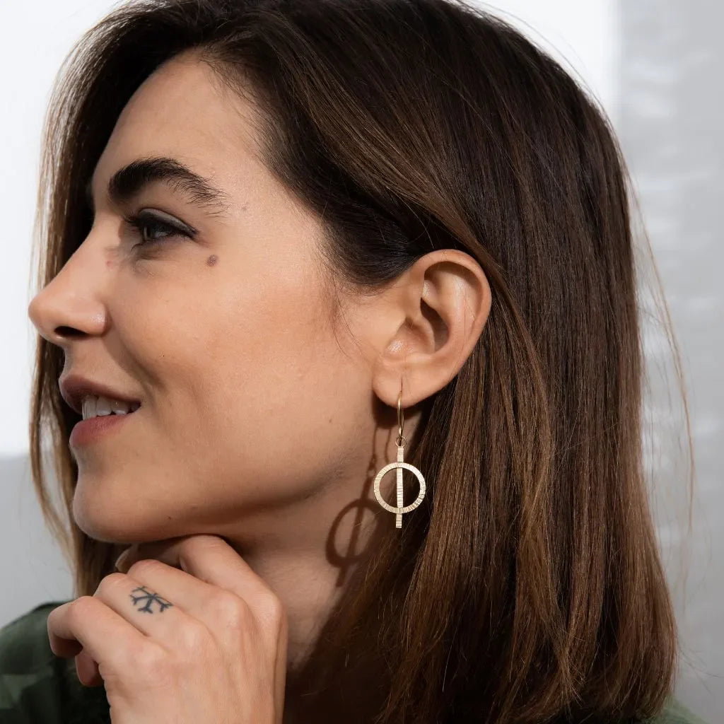 Woman wearing handmade gold vermeil hoop earrings from the Blackbird Jewellery Earrings collection.
