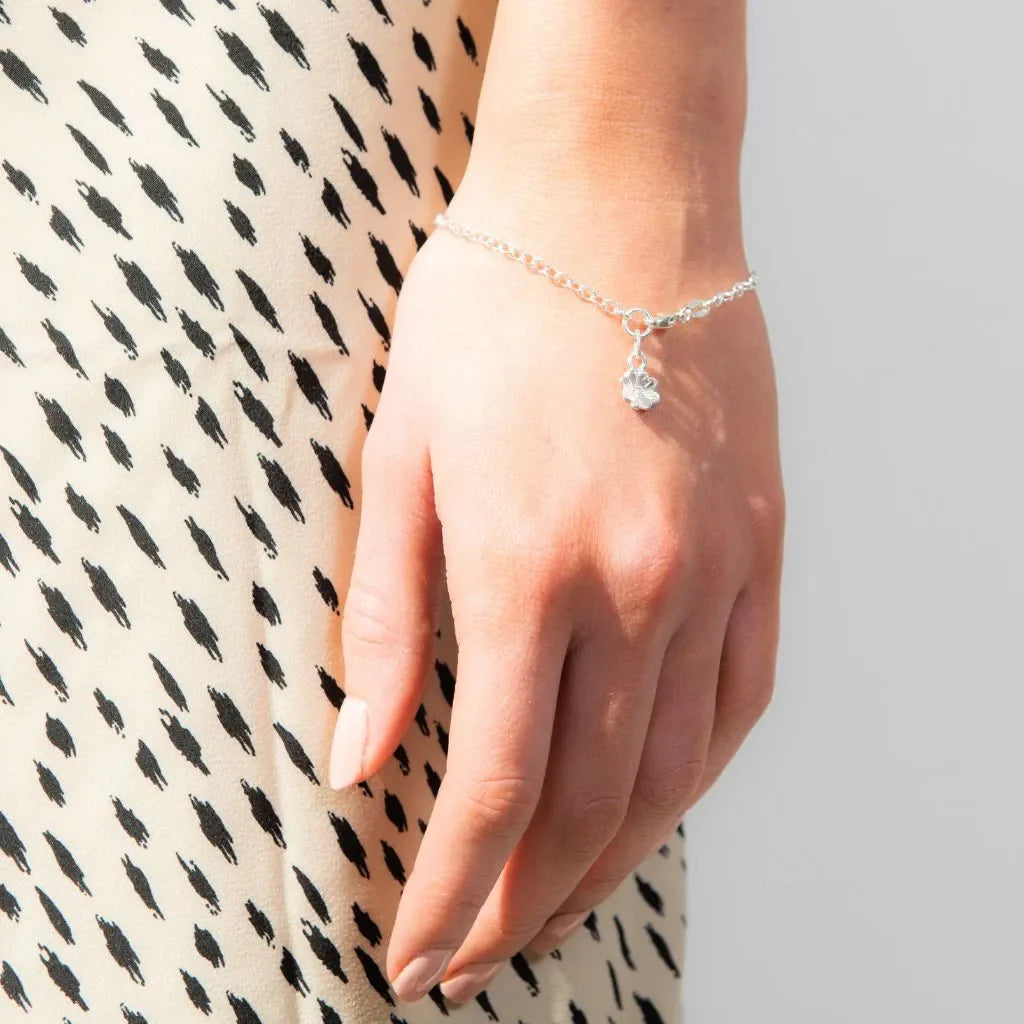 Woman wearing a handmade sterling silver charm bracelet from the Blackbird Jewellery Bracelets collection.