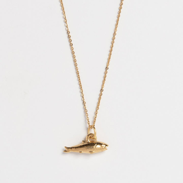 Blackbird Jewellery woman wearing 18ct gold vermeil lucky fish charm necklace with fine chain, handcrafted fish pendant symbolising abundance, prosperity and good luck