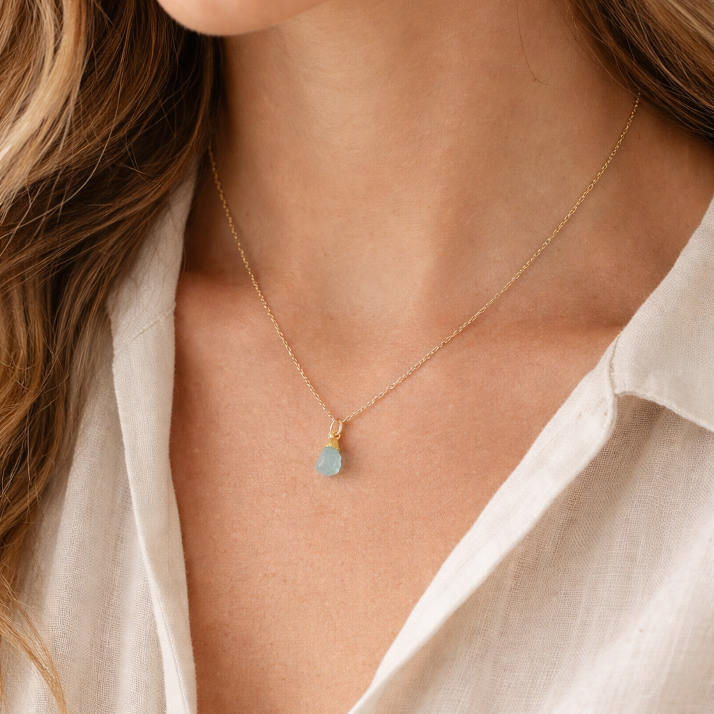 Blackbird Jewellery Gold Vermeil Raw Aquamarine Crystal Necklace worn by a female model with an ivory linen blouse in soft natural light