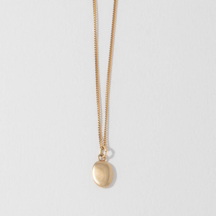 A 18ct Gold Vermeil Small Pebble Necklace with a gold chain and a gold-coloured pebble charm, displayed against a white background.