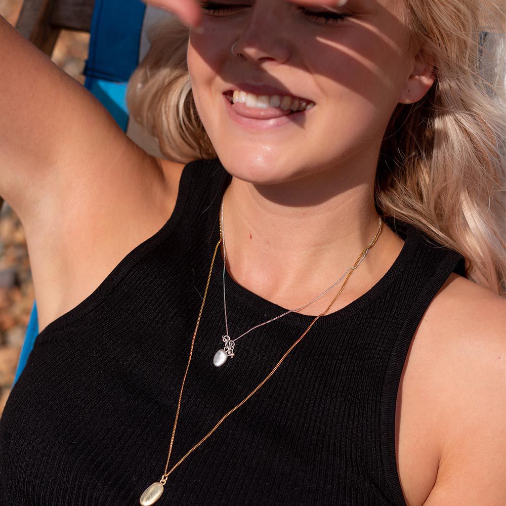 Blackbird Jewellery Model wearing small gold pebble necklace on 45cm chain, minimal coastal jewellery style.