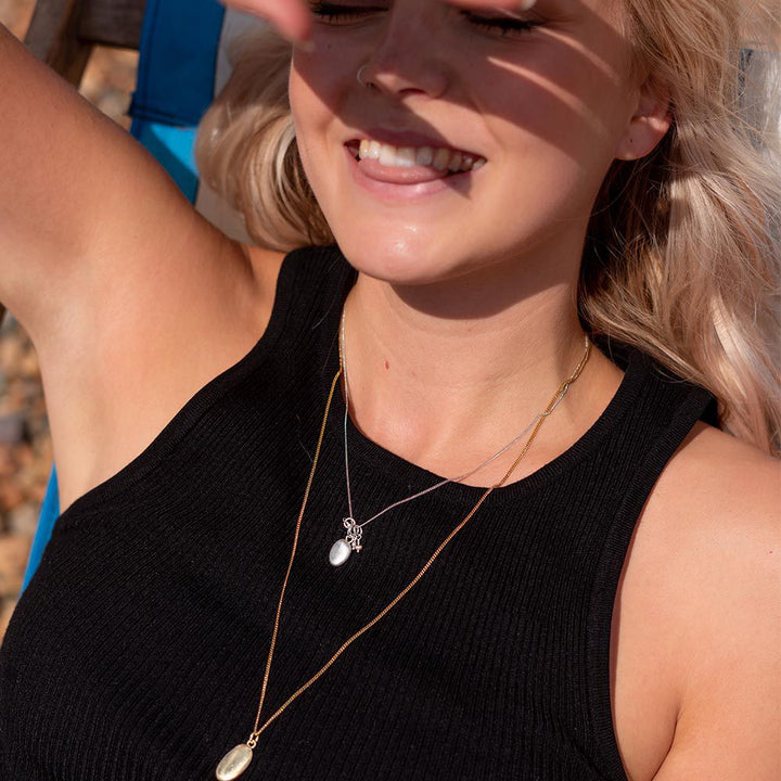 Blackbird Jewellery Model wearing small gold pebble necklace on 45cm chain, minimal coastal jewellery style.