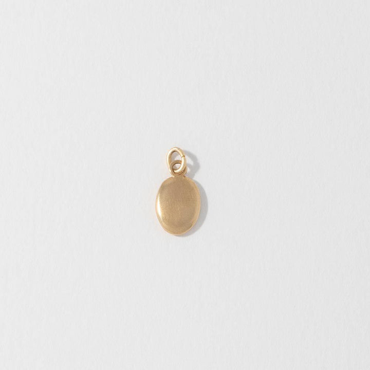 Blackbird Jewellery Small 18ct gold vermeil pebble charm cast from a real beach pebble, front view.