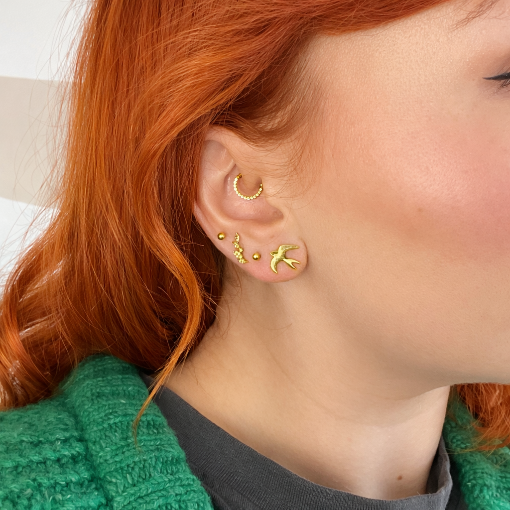Blackbird Jewellery 18ct gold vermeil swallow bird stud earring lifestyle photo on model’s ear