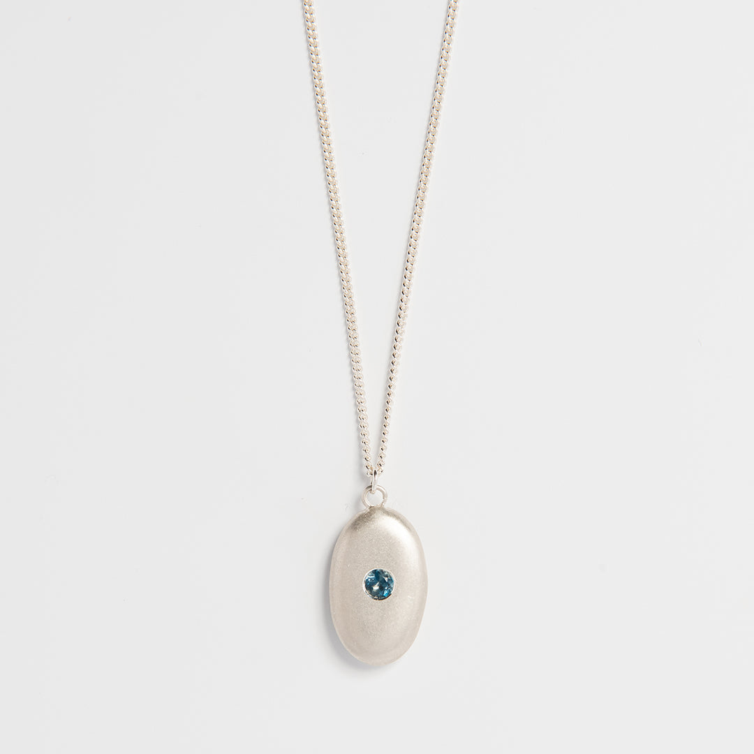 Sterling silver pebble necklace with blue topaz gemstone – handmade sea-inspired jewellery by Blackbird Jewellery