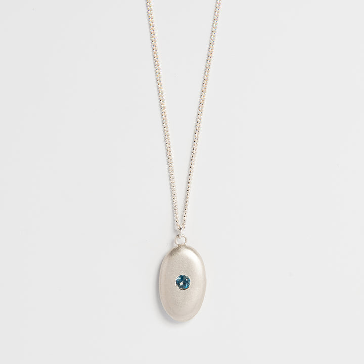 Sterling silver pebble necklace with blue topaz gemstone – handmade sea-inspired jewellery by Blackbird Jewellery