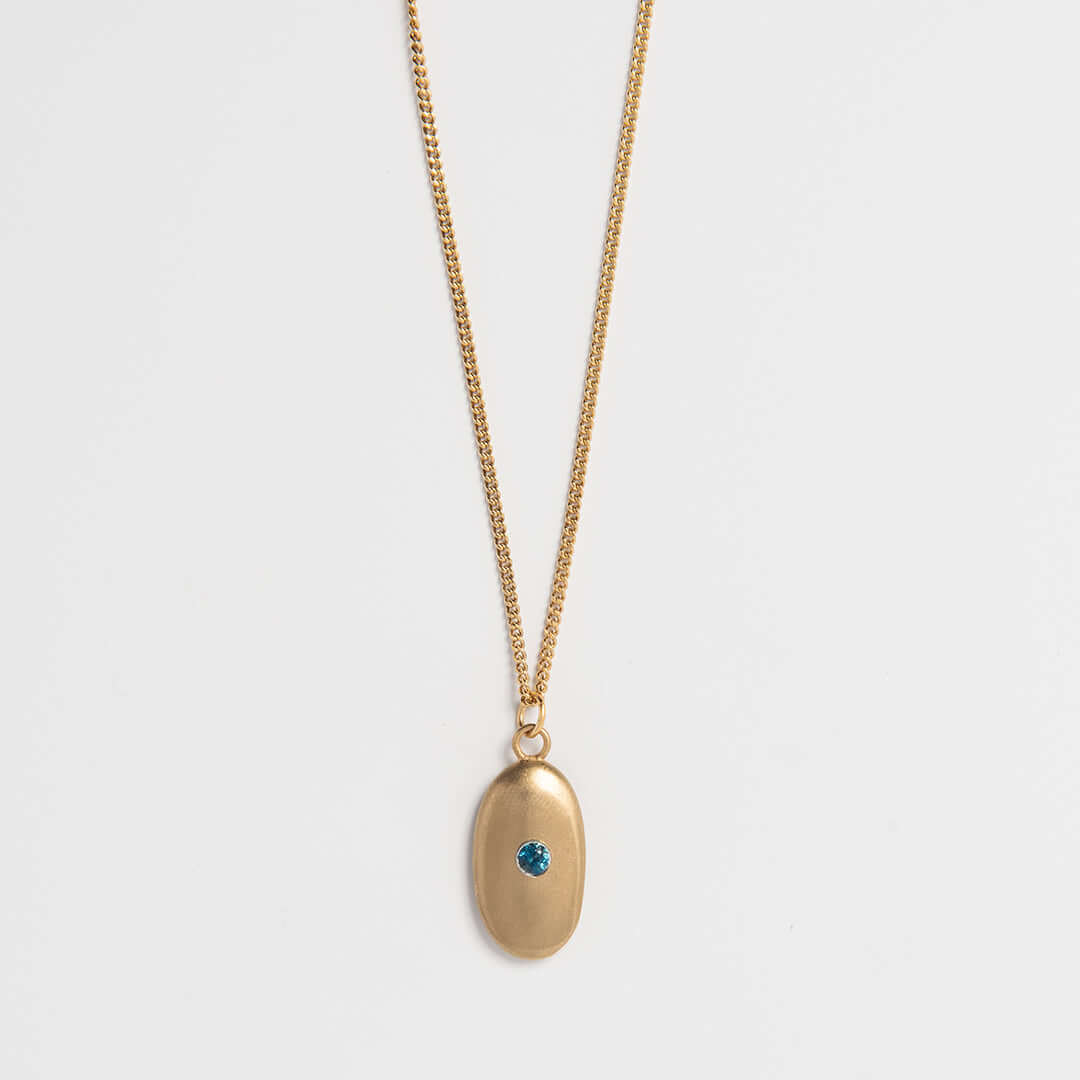 Gold vermeil pebble necklace with blue topaz gemstone – handmade sea-inspired jewellery by Blackbird Jewellery