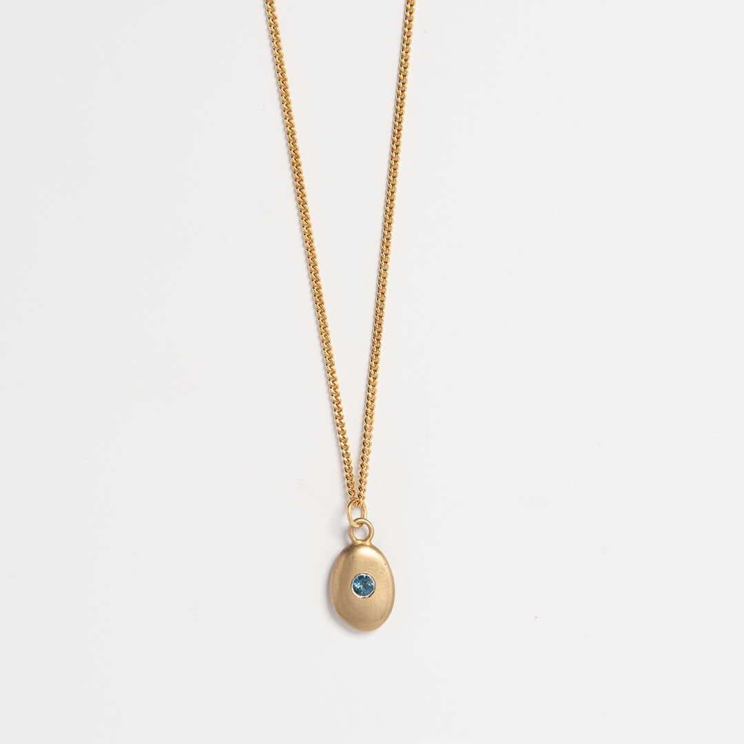 Gold vermeil pebble necklace with blue topaz gemstone – handmade sea-inspired jewellery by Blackbird Jewellery