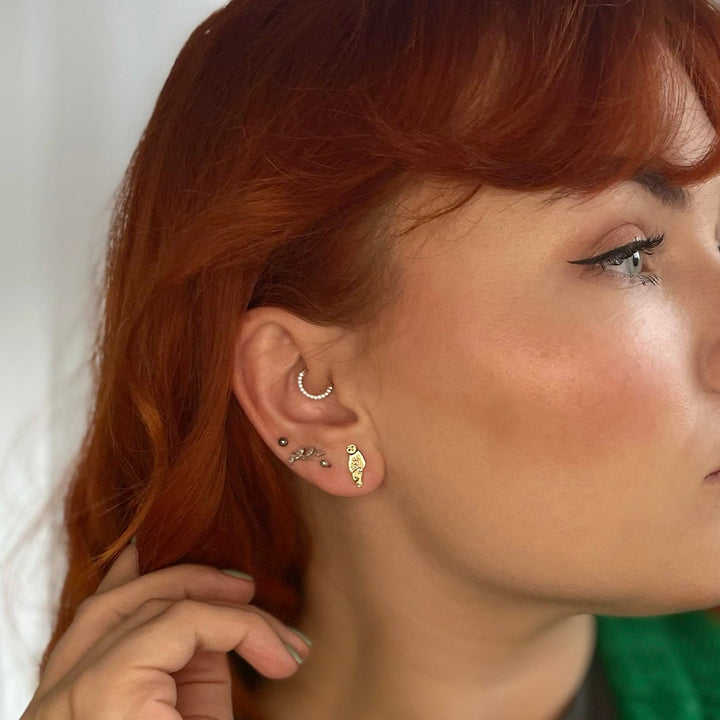 Blackbird Jewellery close-up of model wearing Barn Owl Earrings in 18ct Gold Vermeil, featuring intricate feather-like detailing