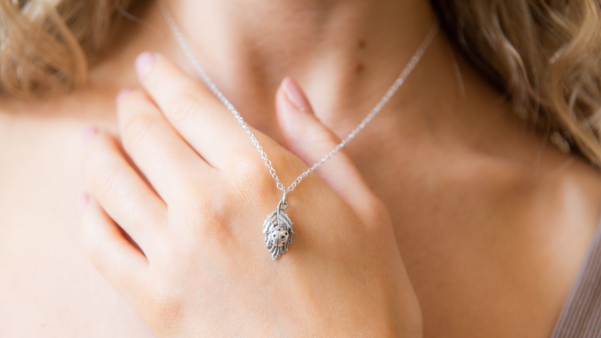Ladybird-themed jewellery styled in a garden setting – symbol of nature, harmony, and wild beauty