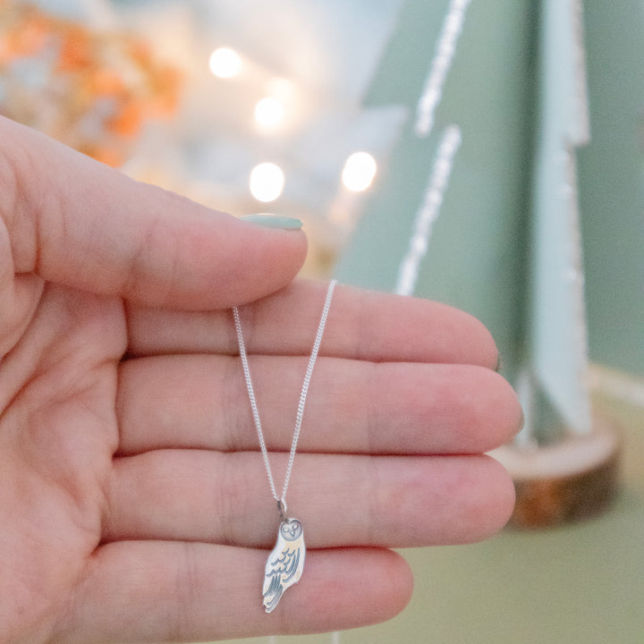 Blackbird Jewellery Sterling Silver Barn Owl Necklace being held by model, highlighting its elegant and nature-inspired craftsmanship.