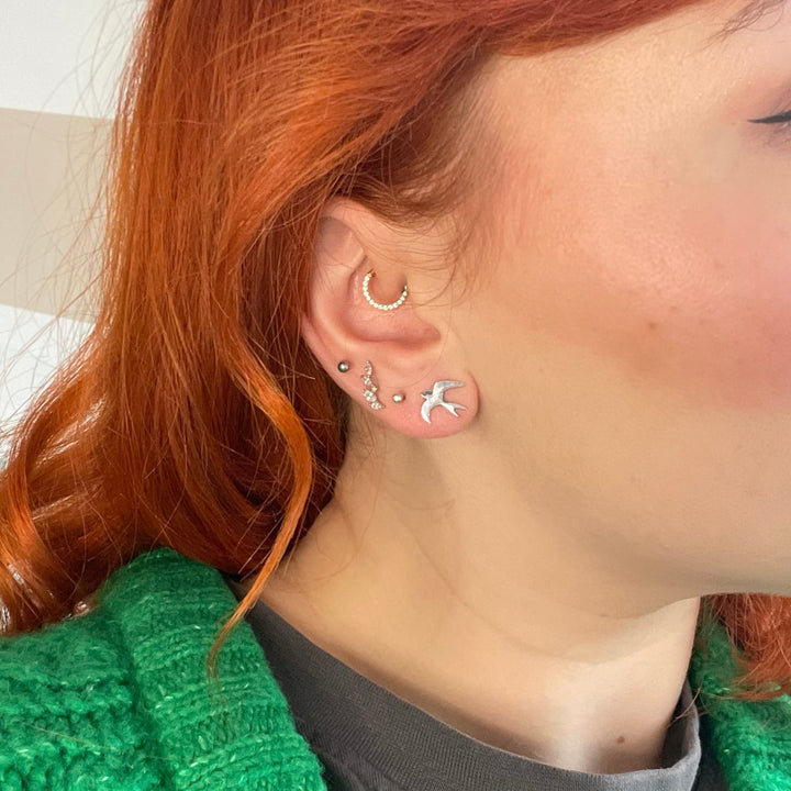 Blackbird Jewellery Sterling Silver Swallow Earrings on a model, handcrafted for a nature-inspired look.