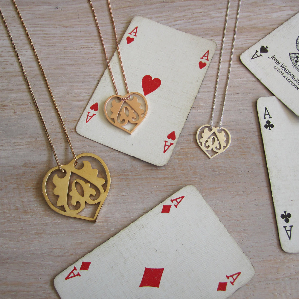 Gold necklaces with heart pendants on playing cards