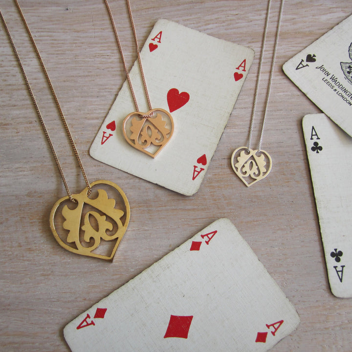 Gold necklaces with heart pendants on playing cards
