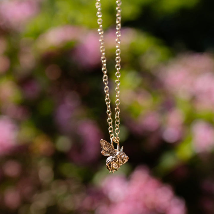 Close-up of the Bee in Flight Necklace in 18ct gold vermeil, showcasing the intricate bee charm with delicate wings and detailed stripes.