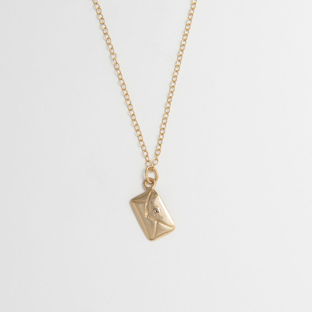 18ct gold vermeil love letter necklace with envelope charm, handmade from recycled silver on a white background