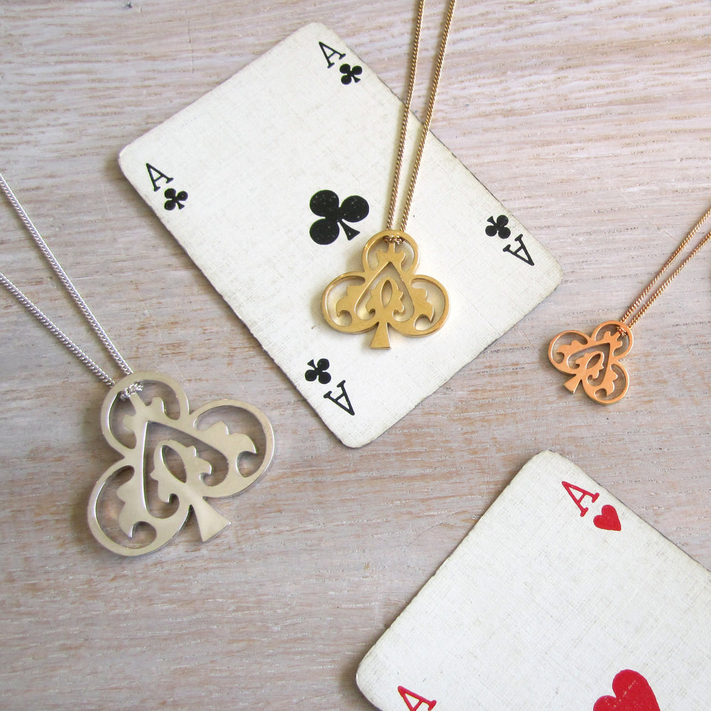 Ace of Clubs gold vermeil necklace styled with playing cards flat lay