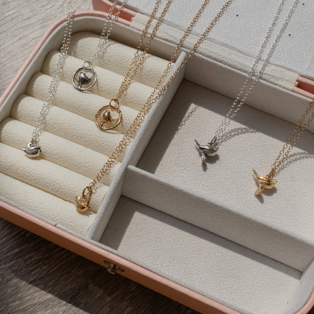 Blackbird Jewellery bird necklaces in sterling silver and 18ct gold vermeil displayed in a jewellery case