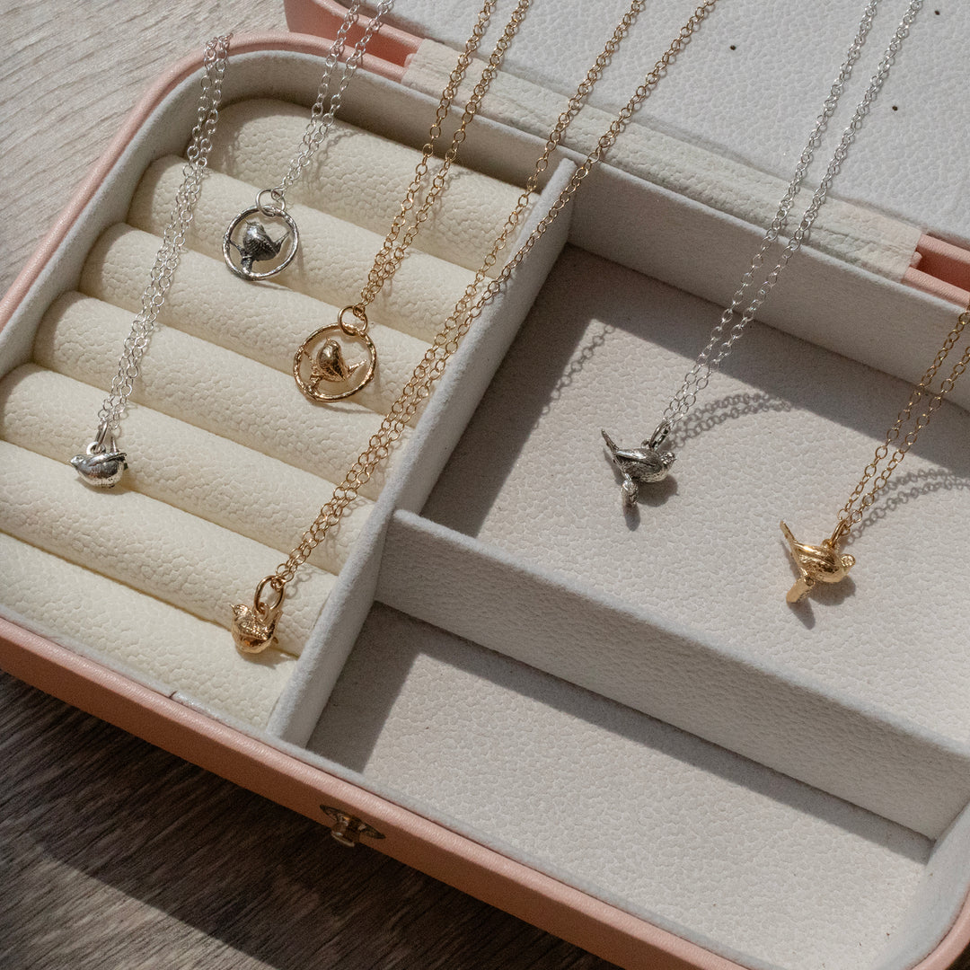 Blackbird Jewellery bird necklaces in sterling silver and 18ct gold vermeil displayed in a jewellery case
