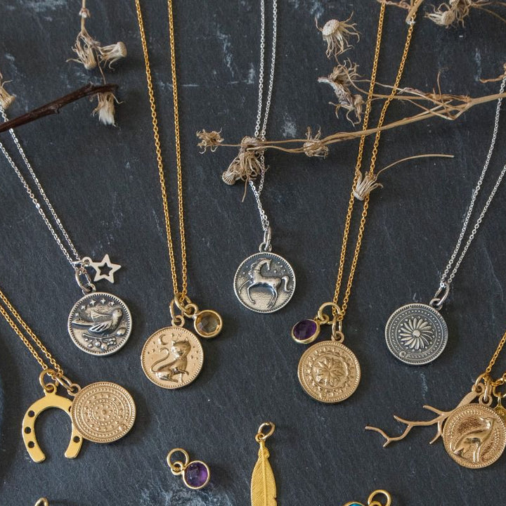 Collection of Blackbird Jewellery Enchanted Animals necklaces featuring mystical animal pendants in silver and gold on a dark background.