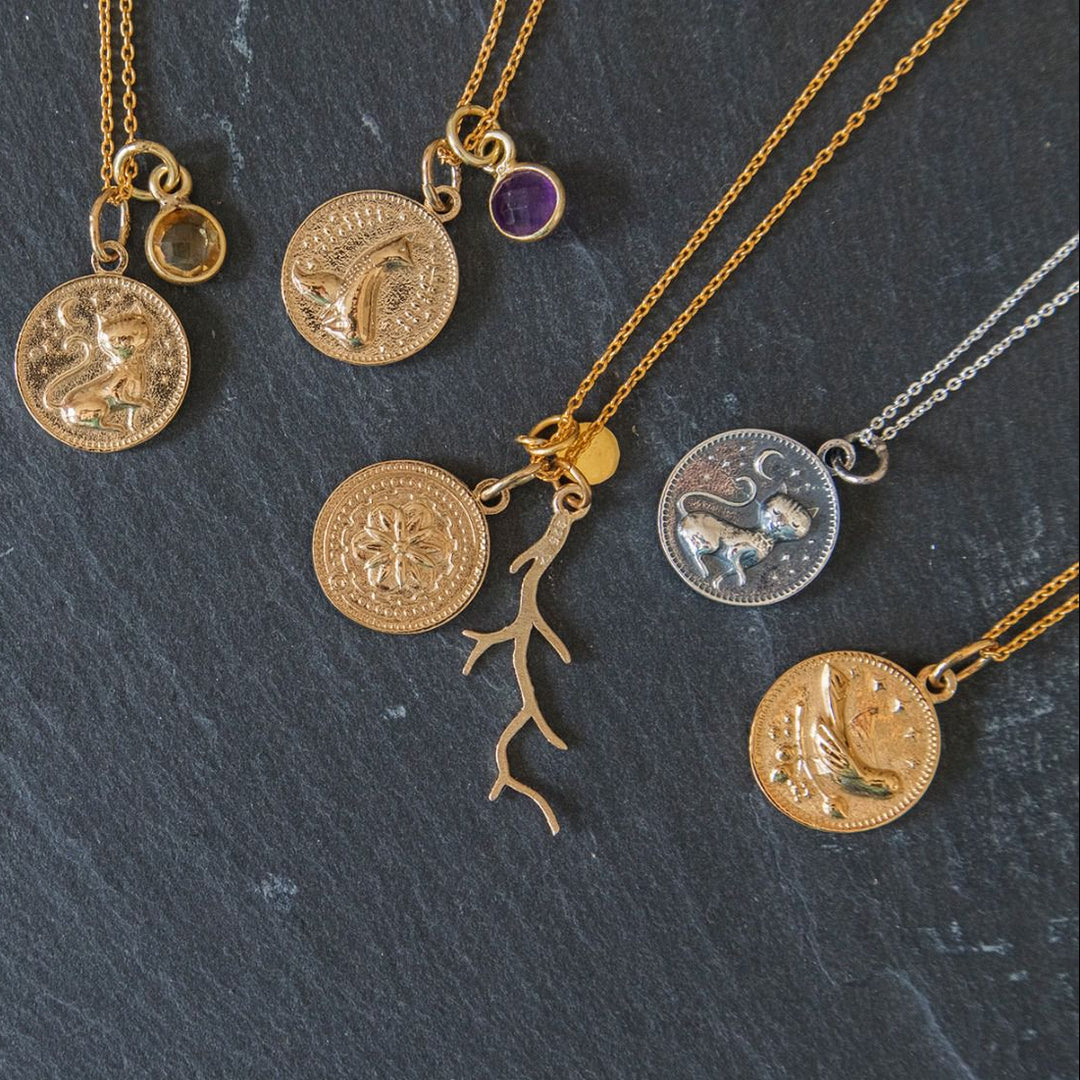 Blackbird Jewellery mystical animal necklaces and charms arranged on a dark background, featuring celestial-inspired silver and gold jewellery.