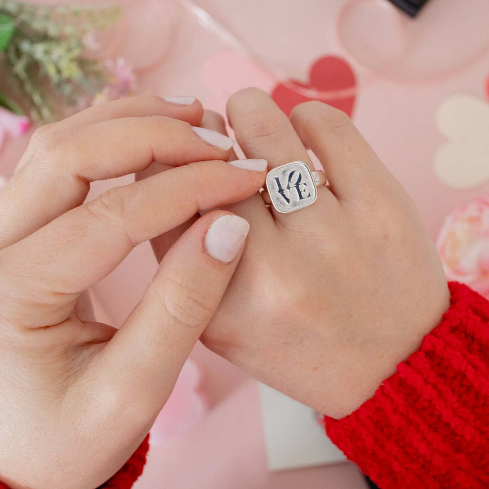 Close-up of Blackbird Jewellery recycled sterling silver ring with graffiti-inspired love design on model