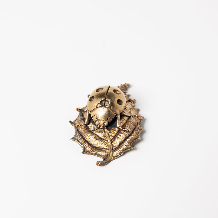Handcrafted bronze ladybird sculpture with detailed wings and leaf perch