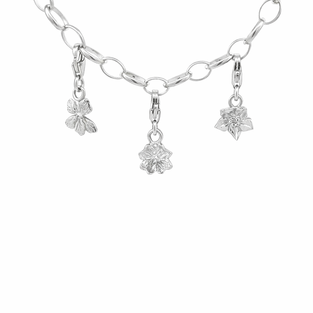 Blackbird Jewellery sterling silver flower clip-on charms attached to a paperclip chain bracelet on a white background