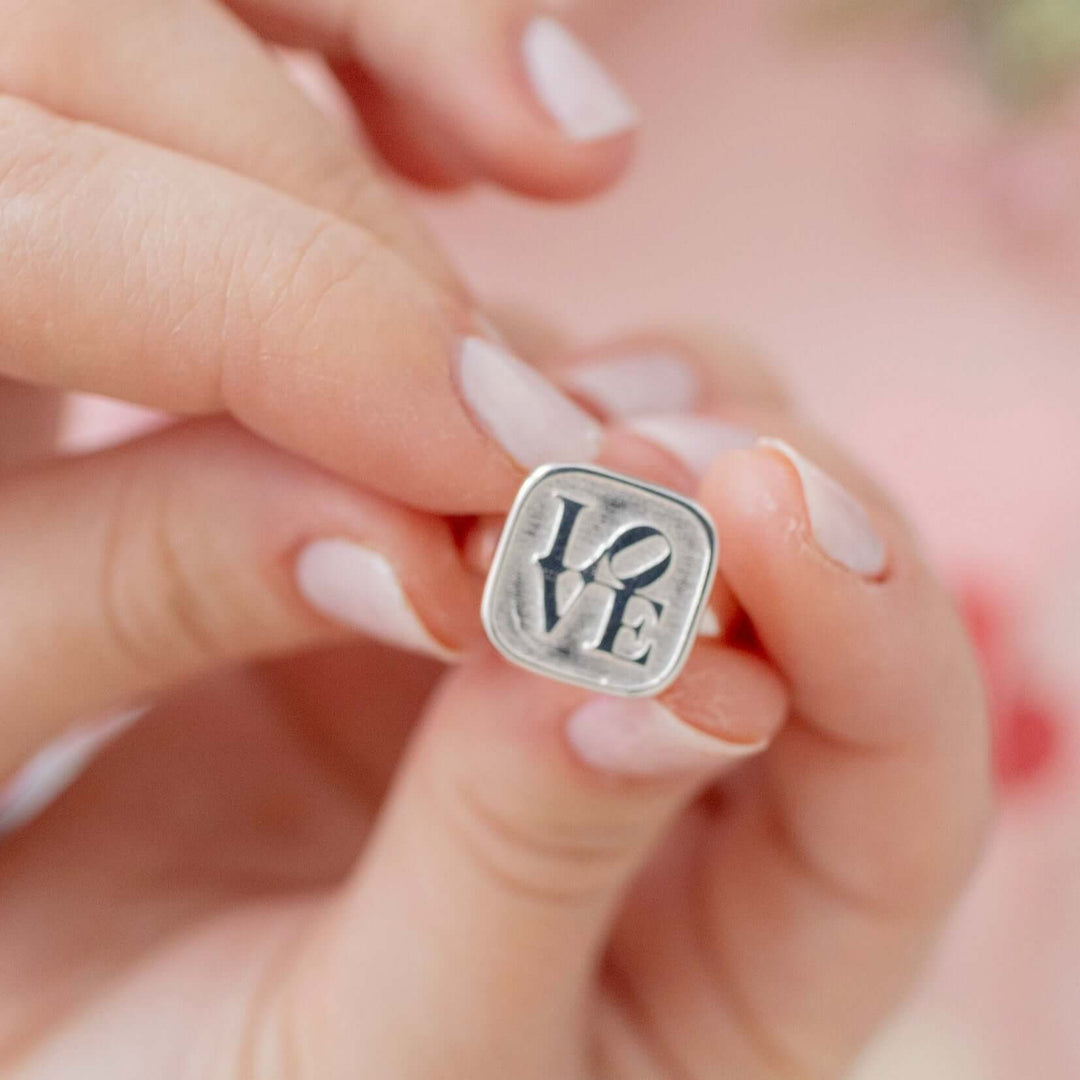 Blackbird Jewellery Sterling Silver Graffiti Love Ring featuring a bold ‘love’ inscription in graffiti style held in hands