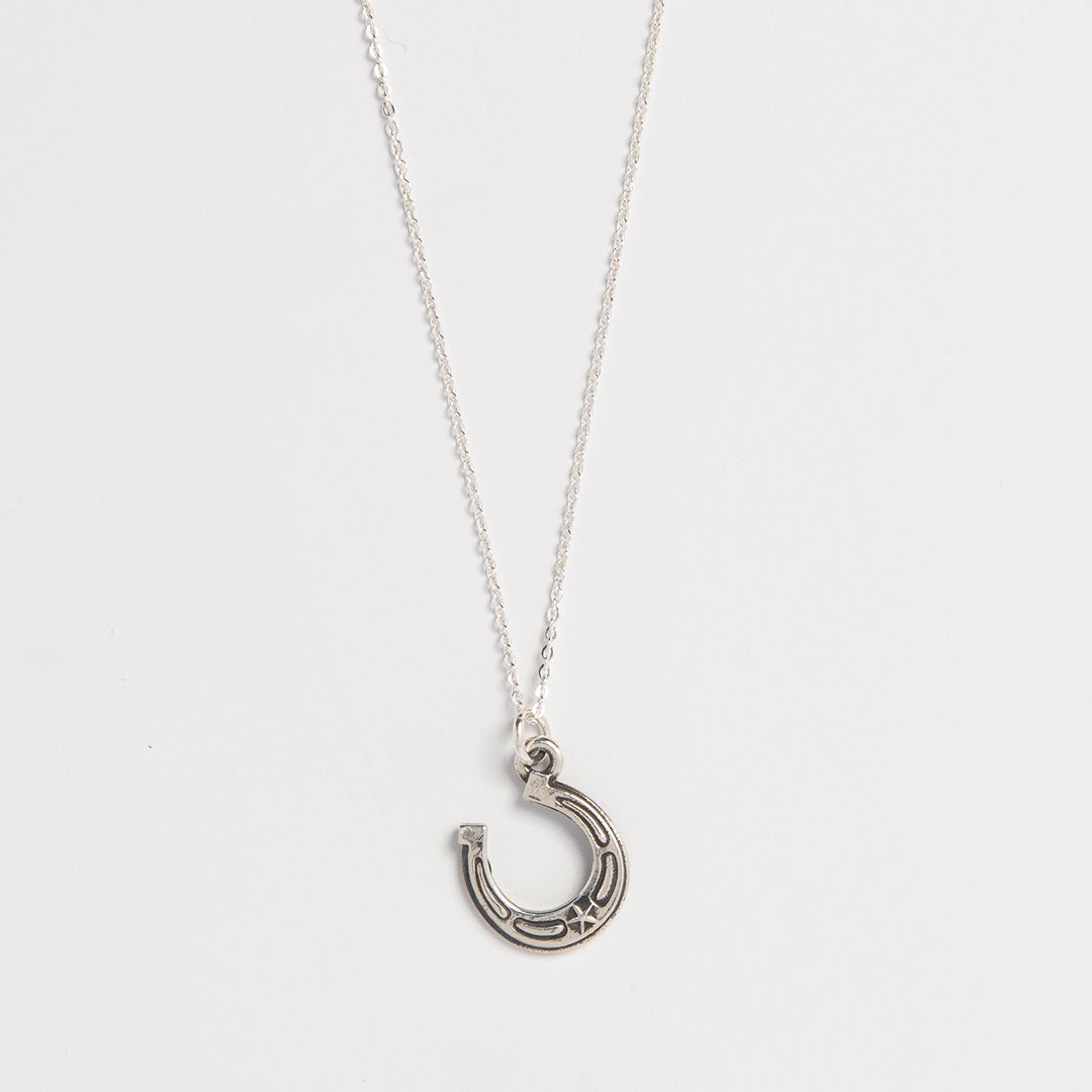 sterling silver lucky horseshoe charm necklace on fine chain handcrafted good luck jewellery by Blackbird Jewellery