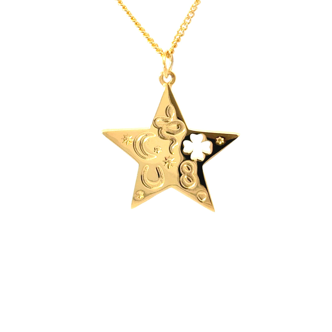 Close-up of gold star pendant featuring moon, stars, clover and horseshoe