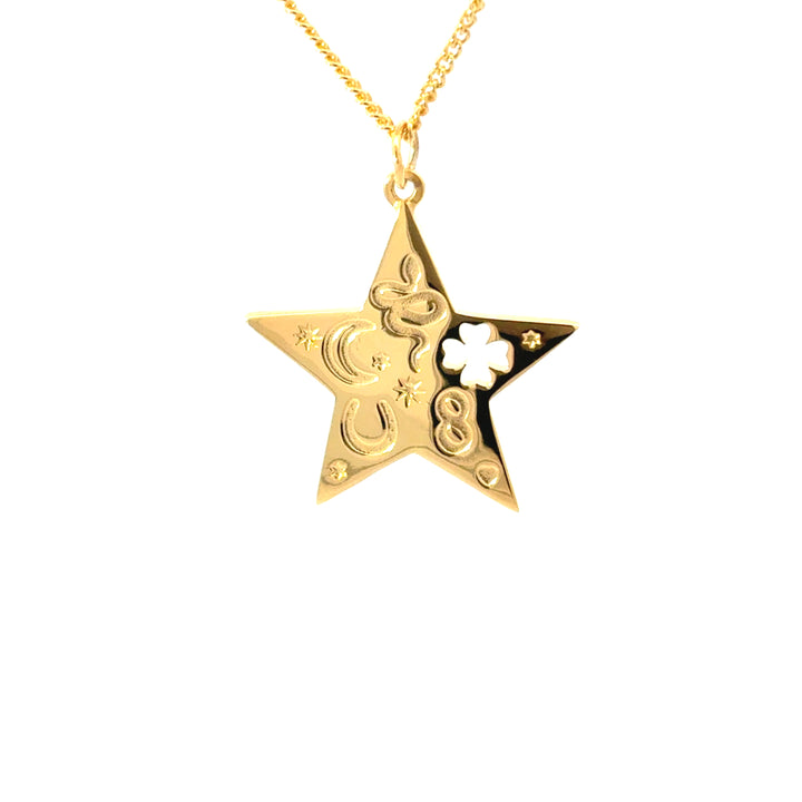 Close-up of gold star pendant featuring moon, stars, clover and horseshoe