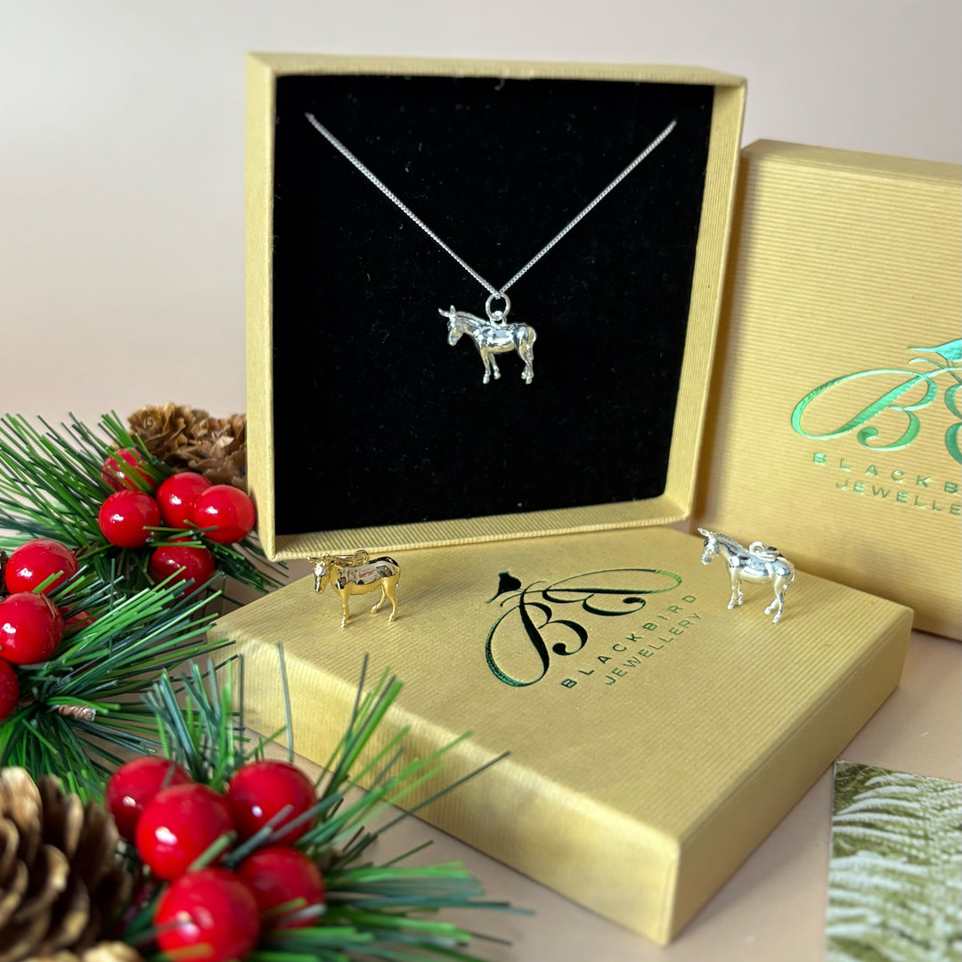 Sterling Silver Donkey necklace in a gold box with Christmas decorations on a white background