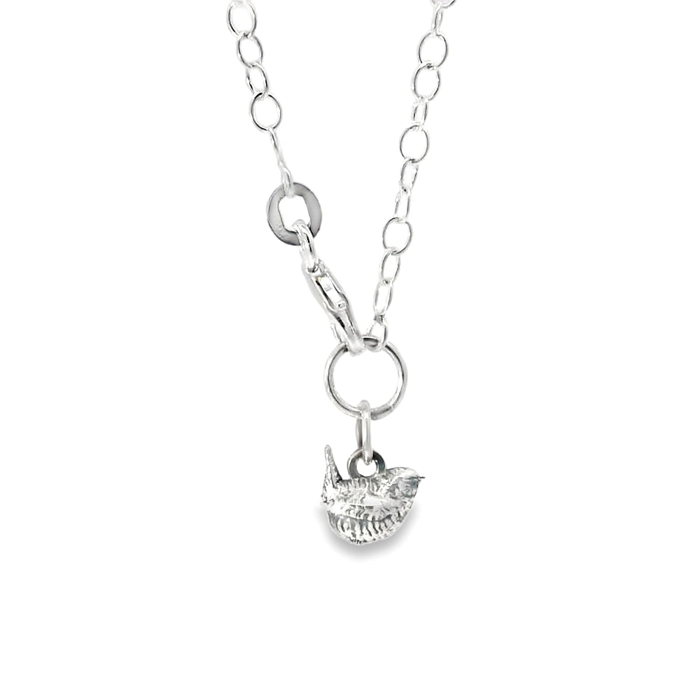 Close-up of a handcrafted wren charm in sterling silver on a 7-inch chain